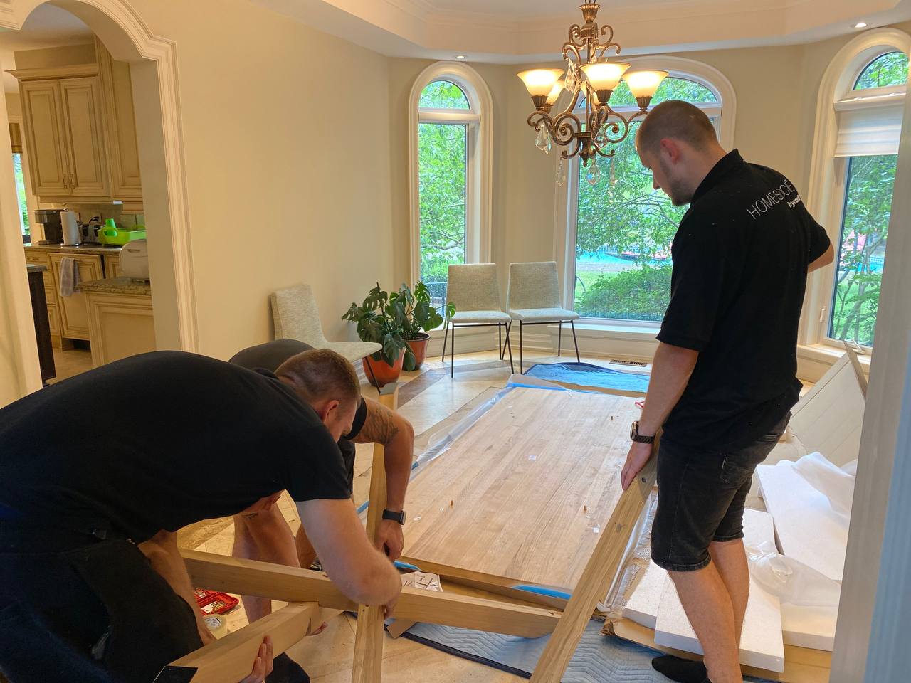 Professional furniture delivery and installation team in Toronto carefully placing a piece of furniture